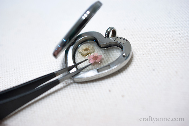 Carefully arranging the small dried flowers with tweezers
